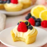 Berry lemon cheesecake cookie cups on white plate with berries