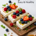 Frozen Greek yogurt bars on marble with berries and almonds